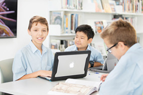 Students reading books and on a laptop