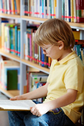 School Child reading a book in the library