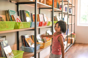 HAIS library - young girl browsing shelves.