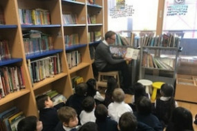 Michael reading to students in the library