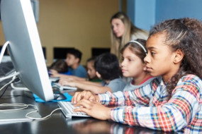 Children playing on computer in the school library 